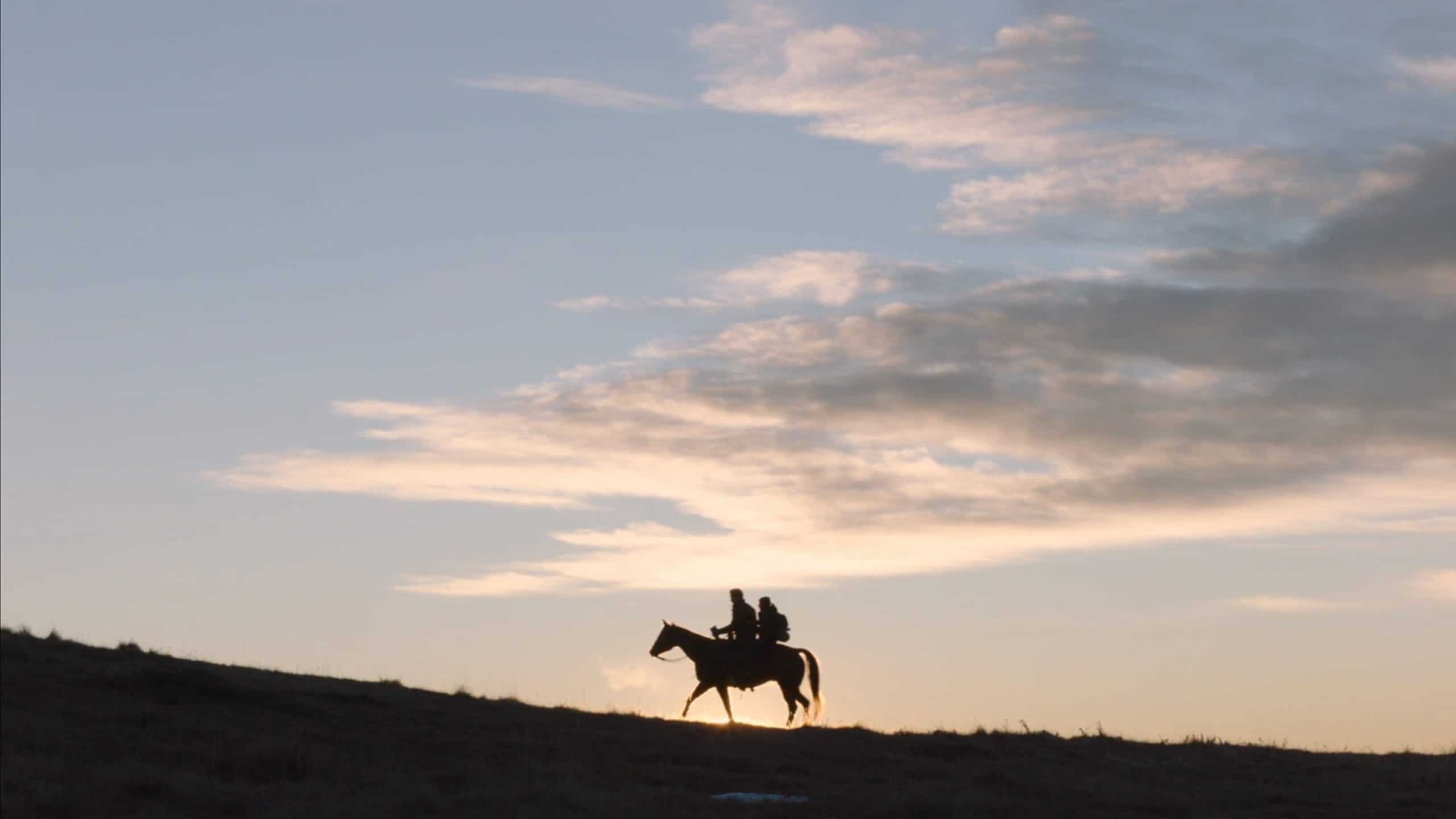 Pedros Pascal as Joel and Bella Ramsey as Ellie on a horse heading to the University of Eastern Colorado