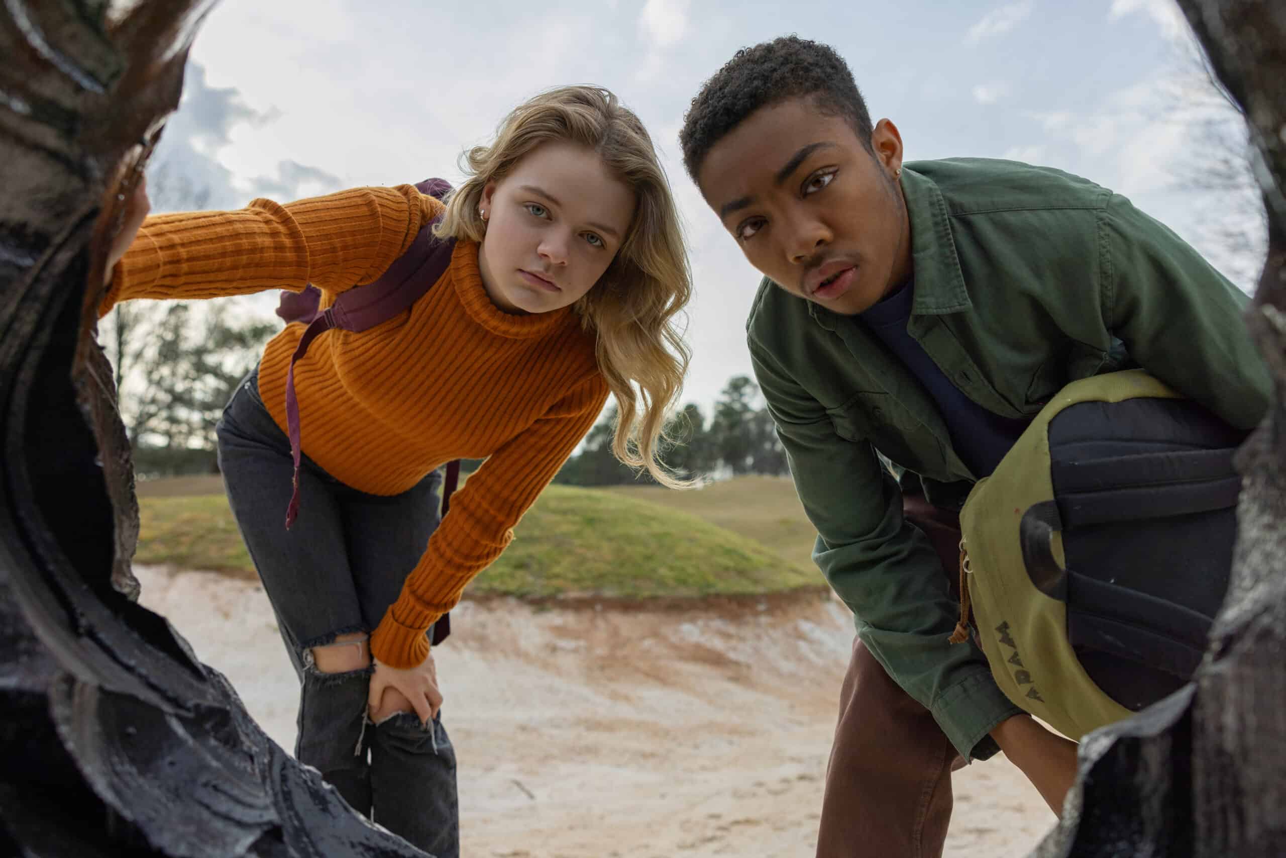 Chloe (Kylie Rogers) and Adam (Asante Blackk) looking down a hole which is the entrance to a Vuvv's home