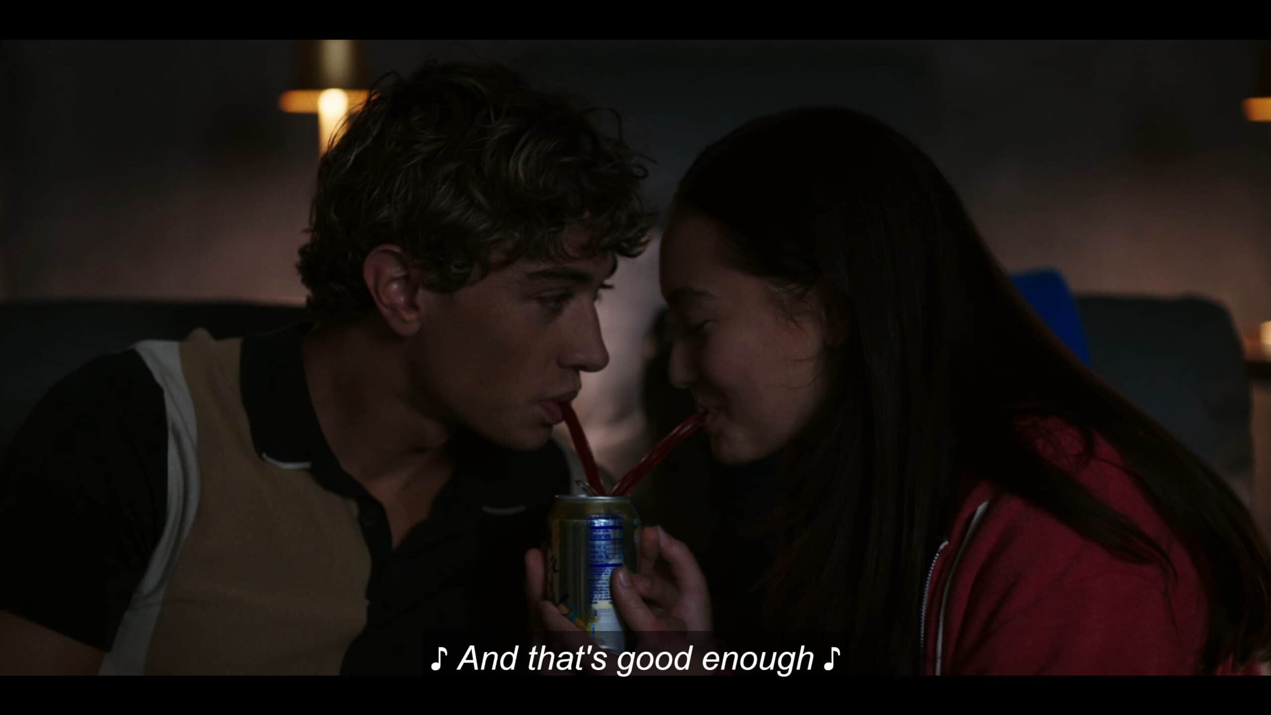 Jeremiah (Gavin Casalegno) and Belly (Lola Tung) sharing a drink, with him looking at her and her down at the drink