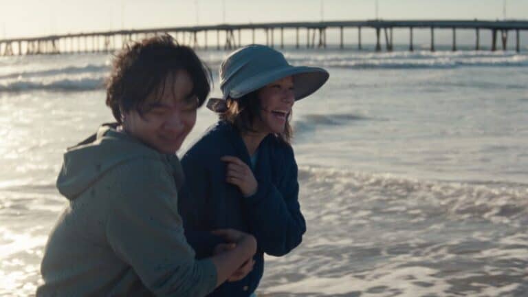 Joe (Lawrence Shou) and Irene (Lucy Liu) on a beach, smiling, and having a rare good moment, in Rosemead