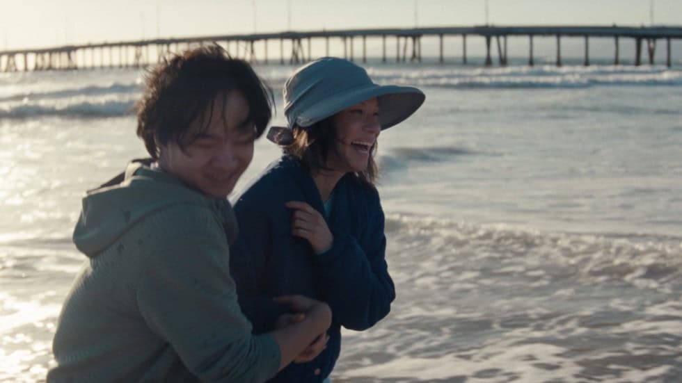 Joe (Lawrence Shou) and Irene (Lucy Liu) on a beach, smiling, and having a rare good moment, in Rosemead | Joe Lawrence Shou and Irene Lucy Liu Rosemead Joe (Lawrence Shou) and Irene (Lucy Liu) on a beach, smiling, and having a rare good moment, in Rosemead