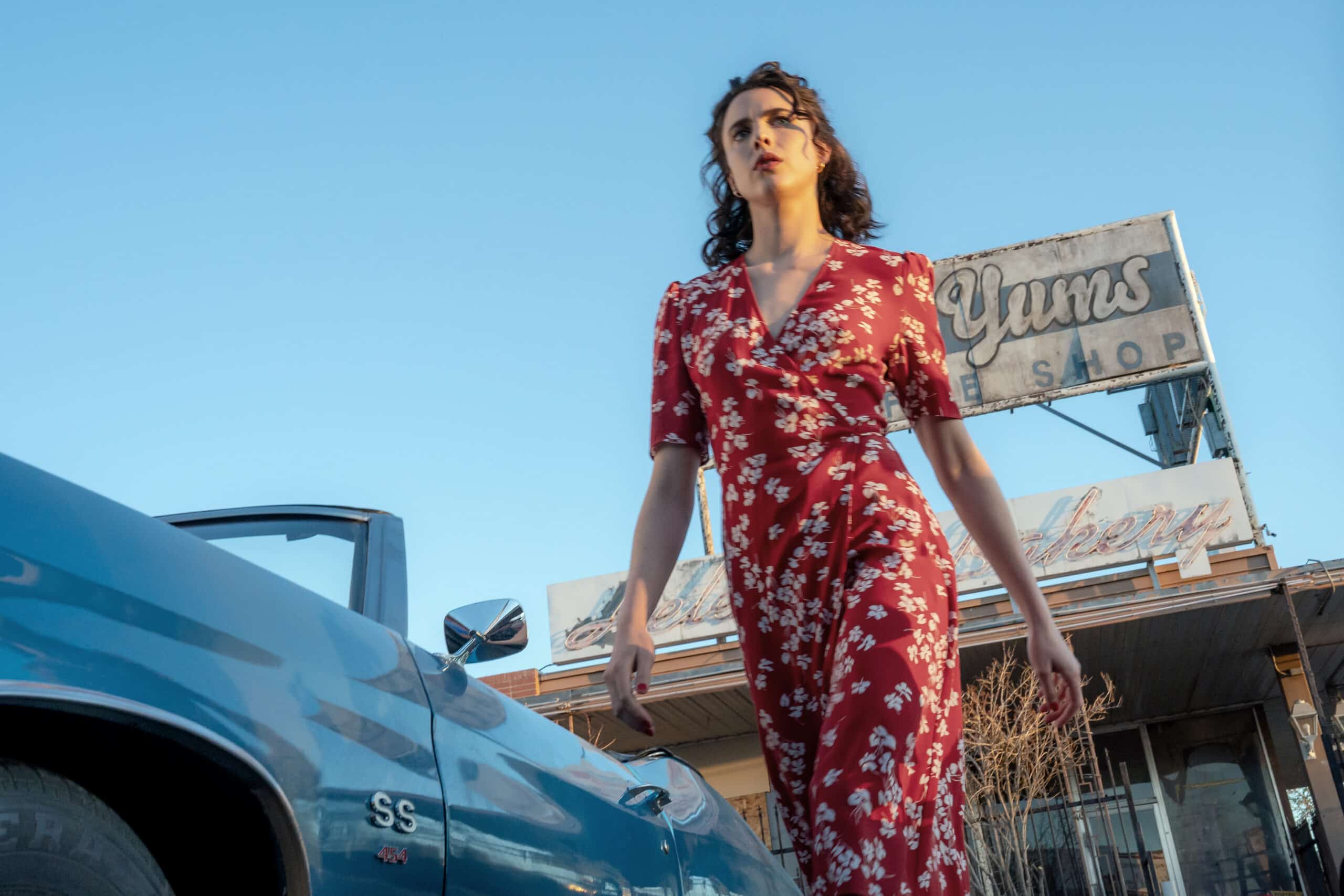 Honey (Margaret Qualley) walking in a red dress